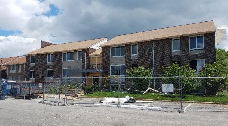 Workers fixing damage to the exterior of a building