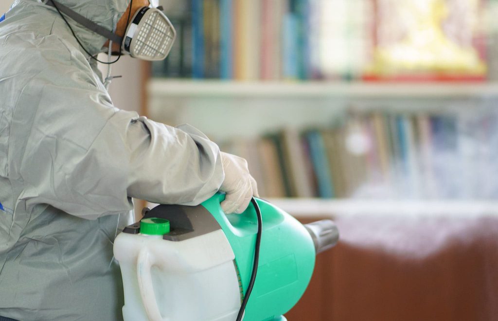 A worker using an electrostatic sprayer