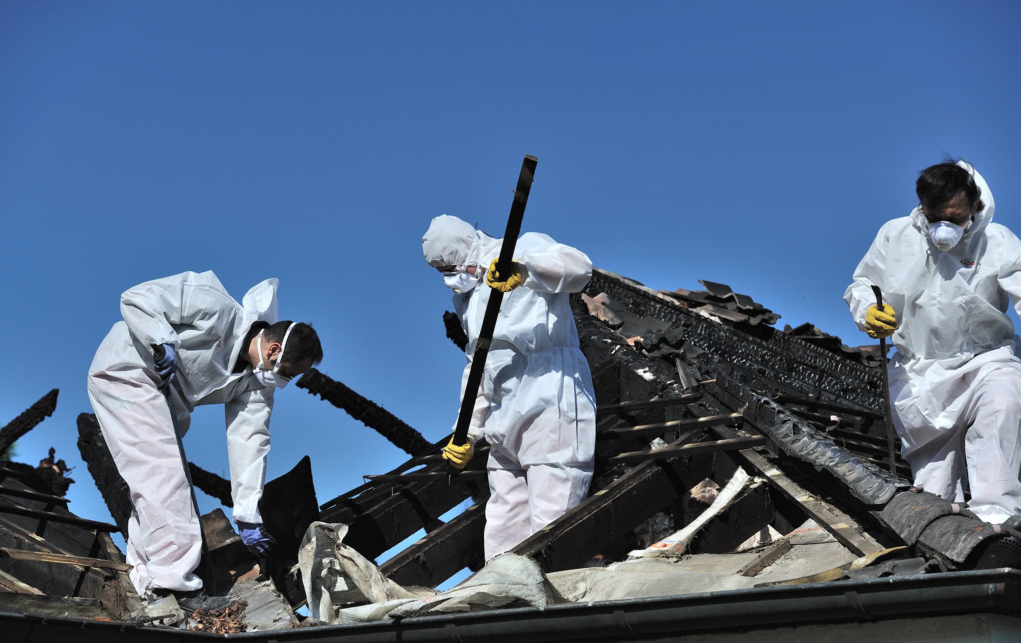 Men working on the roof of a fire-destroyed building