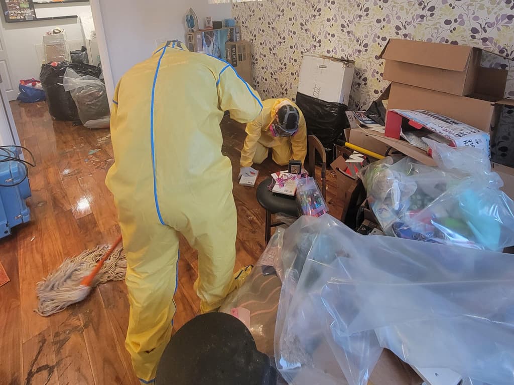 Workers wearing PPE cleaning up biohazard material