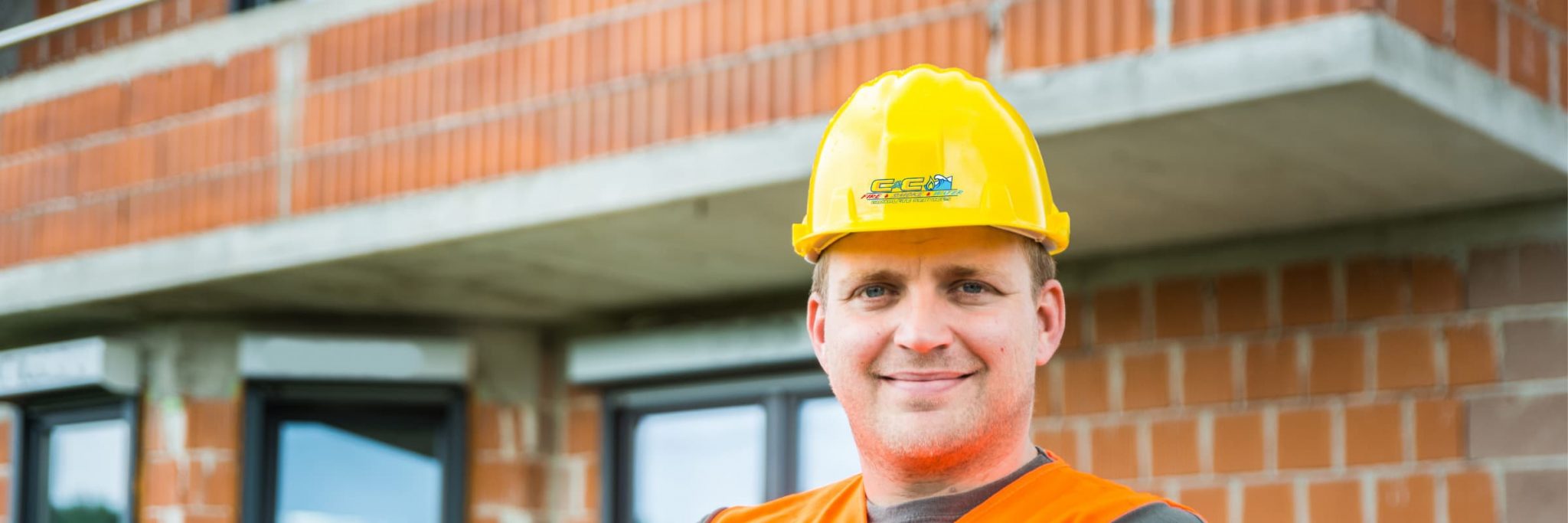 A man wearing a hard hat with the C&C logo